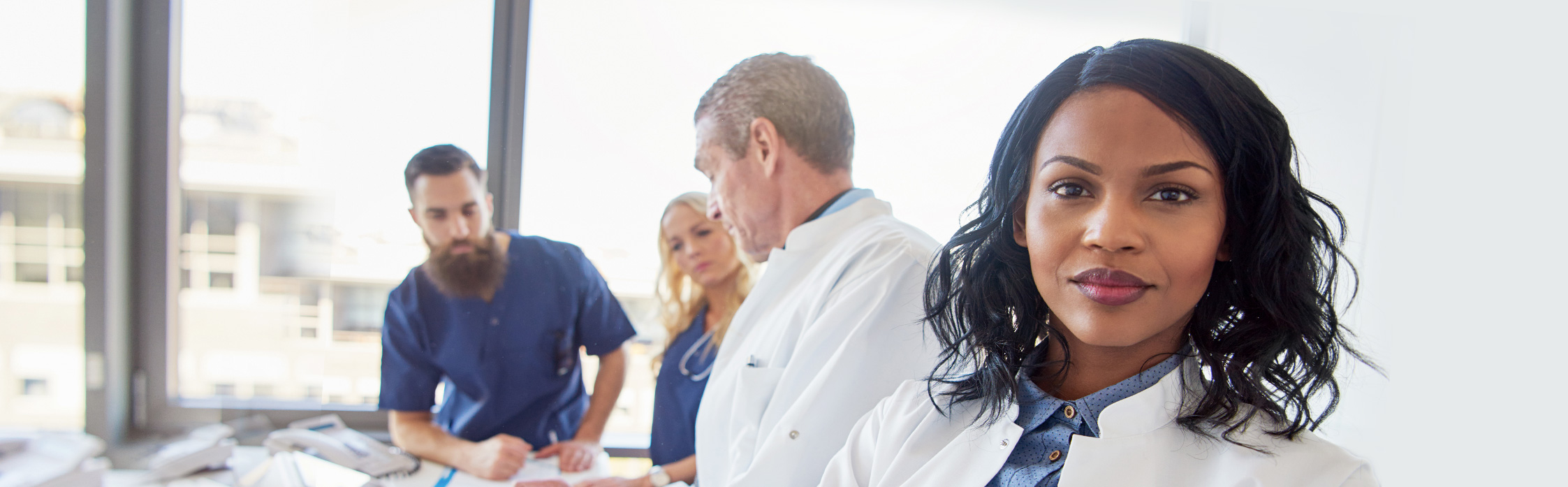 Picture of people wearing white coats with blue in the back